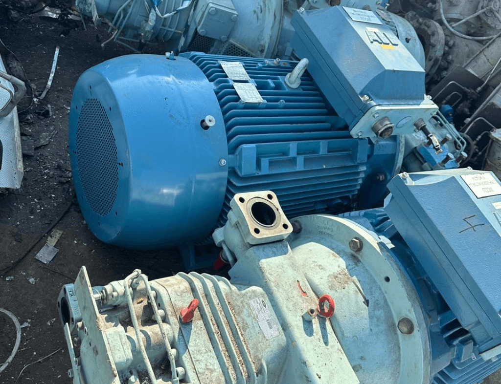 Scrap Electric Motors Buyer in Dubai – Used electric motors with rust and exposed wiring in an industrial scrapyard.