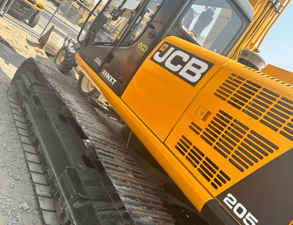 Scrap heavy equipment buyers in Dubai - Used excavators, bulldozers, and cranes in an industrial scrapyard with metal scrap for sale.